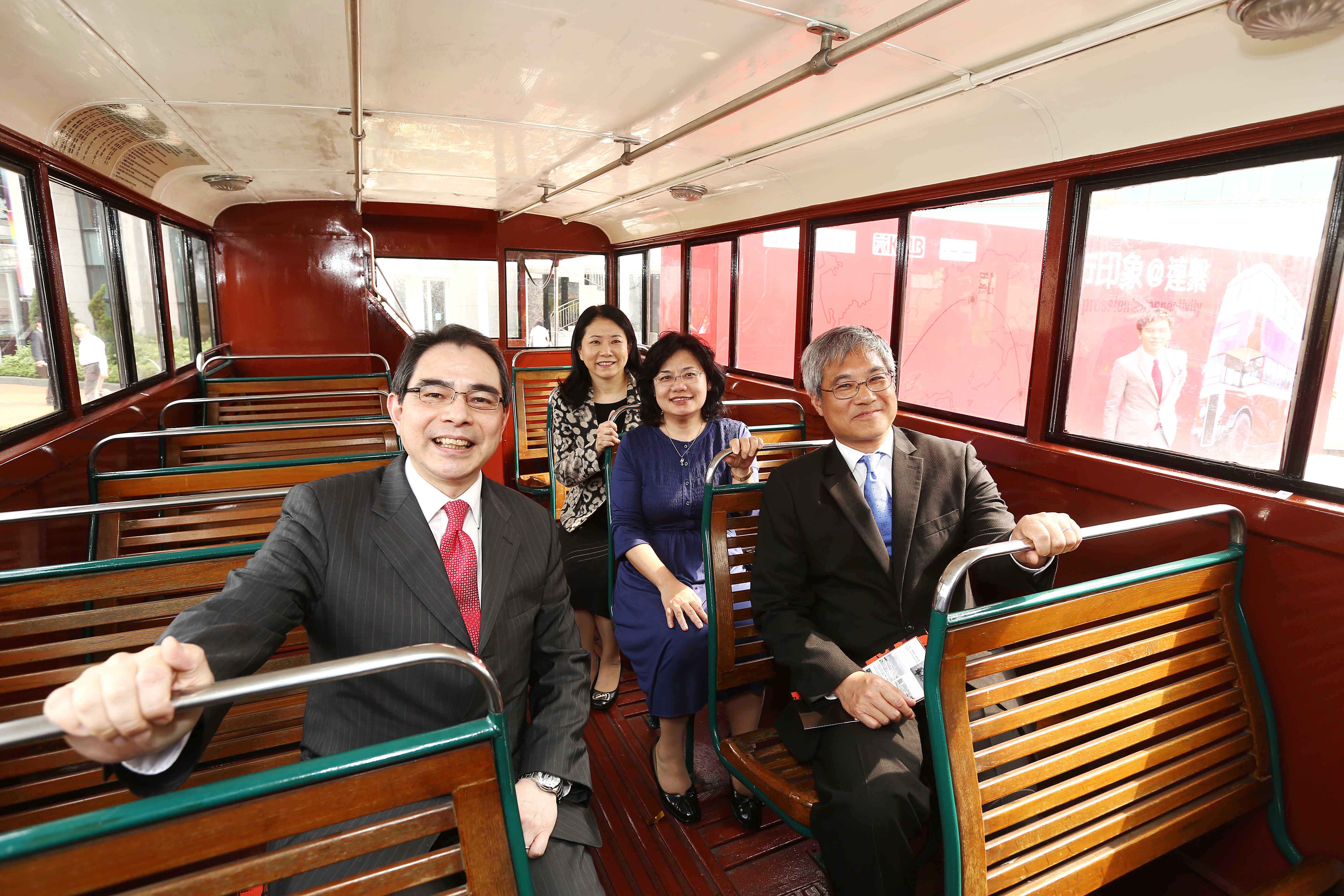 The four officiating guests on the upper deck of the vintage Daimler A bus.